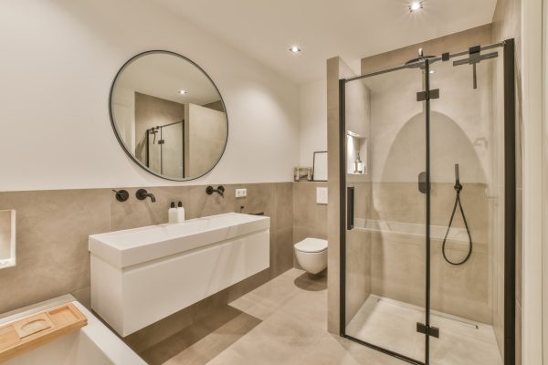 a bathroom with a shower, toilet and sink in the same color as it appears on the wall next to the mirror